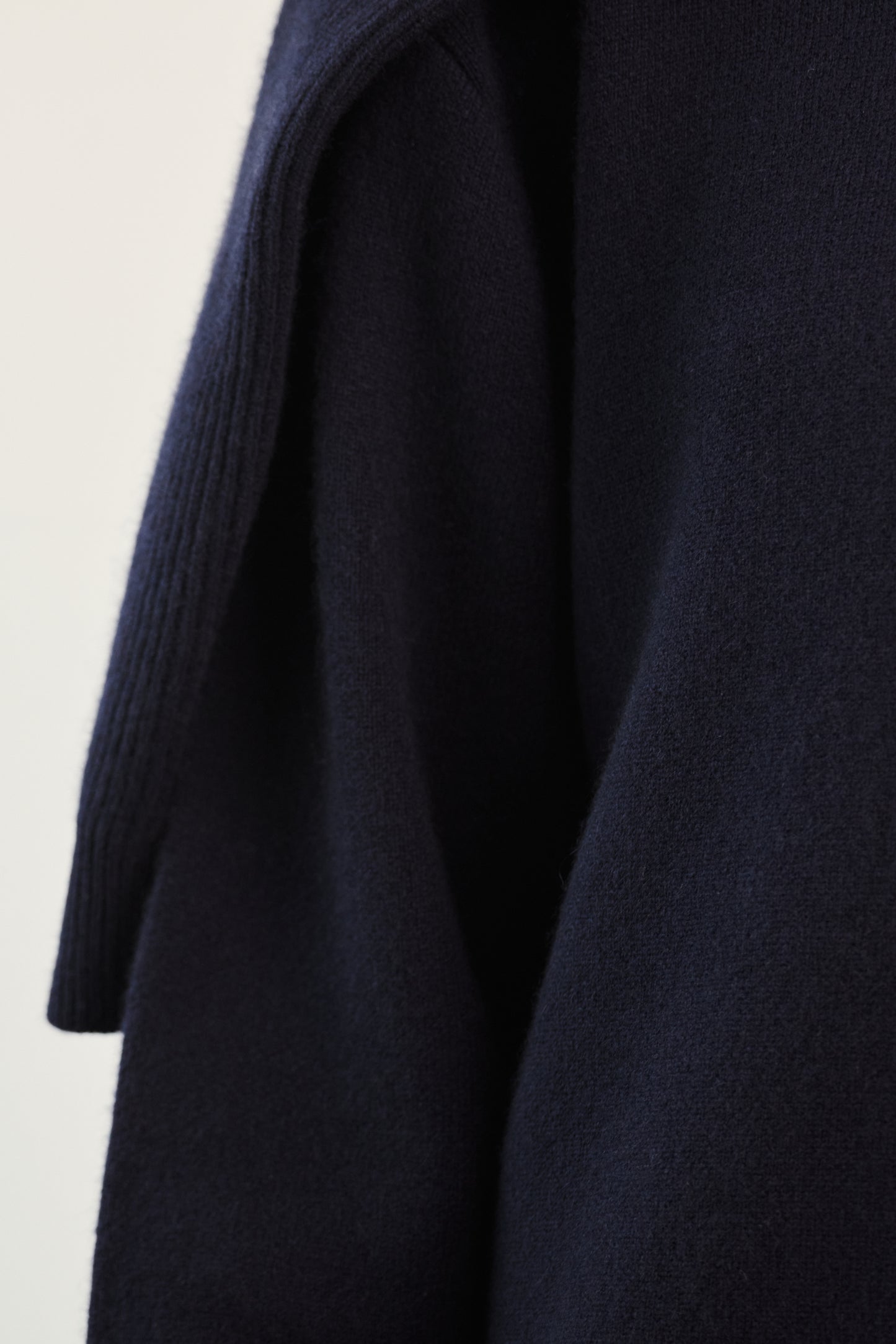 This image features the Axa Sweater, highlighted in a minimalistic style with a ocean color. The sweater showcases an oversized fit with distinct drop shoulders and sculpted, rounded sleeves.