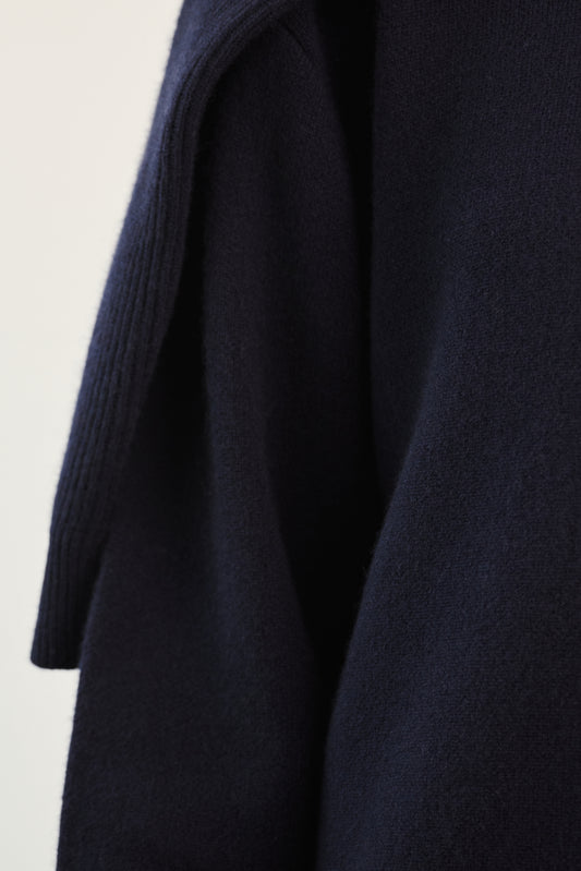 This image features the Axa Sweater, highlighted in a minimalistic style with a ocean color. The sweater showcases an oversized fit with distinct drop shoulders and sculpted, rounded sleeves.