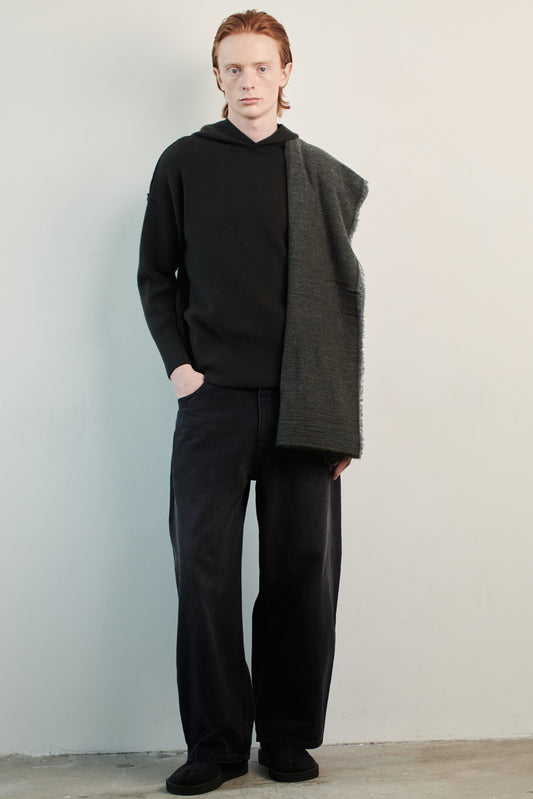 This image features a luxurious forest cashmere hoodie, displayed against a neutral background to emphasize its design and color. The hoodie boasts a modern and minimalist look, with a soft and snug fit that promises comfort and style. Over the shoulder is a shawl to complete the elegant look.