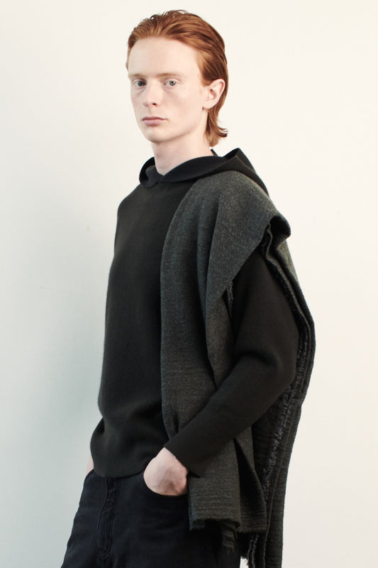 This image features a luxurious forest cashmere hoodie, displayed against a neutral background to emphasize its design and color. The hoodie boasts a modern and minimalist look, with a soft and snug fit that promises comfort and style. Over the shoulder is a shawl to complete the elegant look.