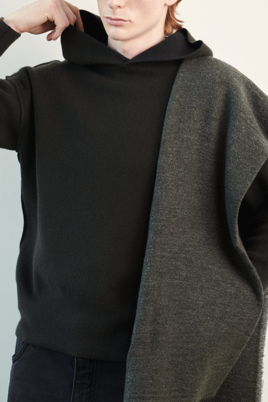 This image features a luxurious forest cashmere hoodie, displayed against a neutral background to emphasize its design and color. The hoodie boasts a modern and minimalist look, with a soft and snug fit that promises comfort and style. Over the shoulder is a shawl to complete the elegant look.