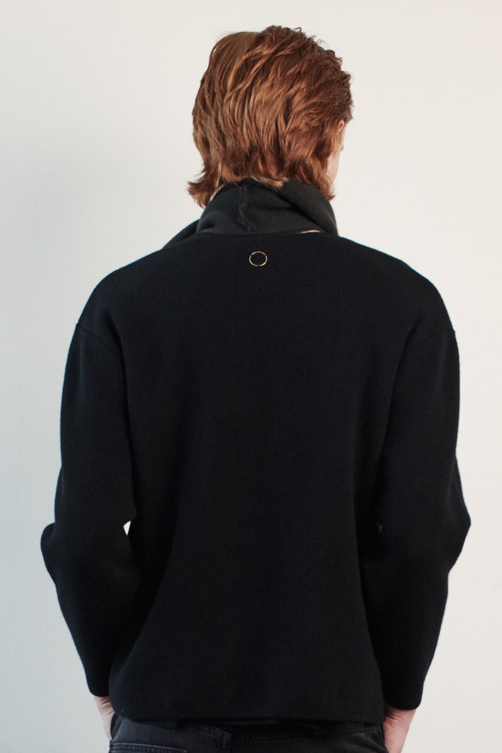 This image features the Axa Sweater, highlighted in a minimalistic style with a black color. The sweater showcases an oversized fit with distinct drop shoulders and sculpted, rounded sleeves.