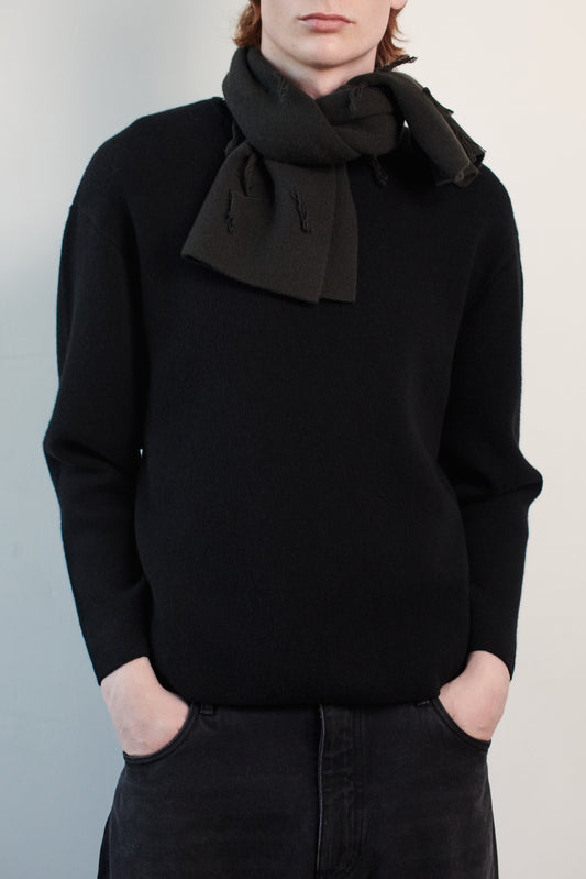 This image features the Tia Neck Warmer, a stylish and cozy accessory designed for chilly days. The neck warmer is presented in a versatile dark color, knitted with a soft texture that emphasizes comfort and warmth.