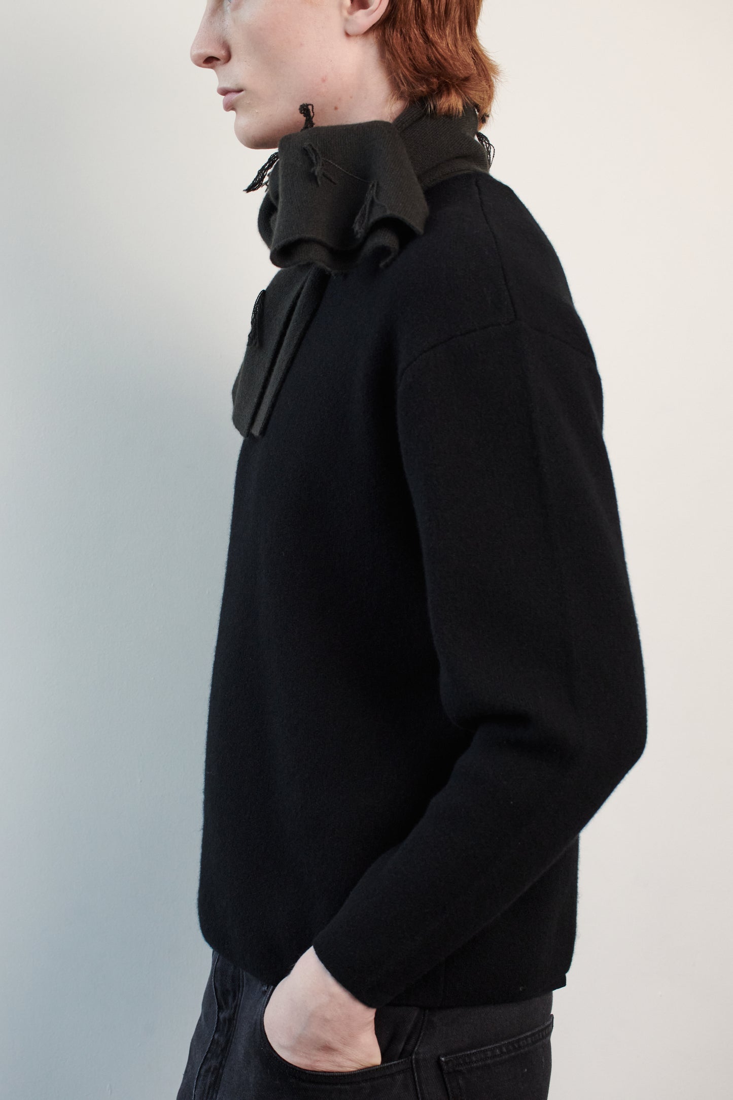 This image features the Axa Sweater, highlighted in a minimalistic style with a black color. The sweater showcases an oversized fit with distinct drop shoulders and sculpted, rounded sleeves.