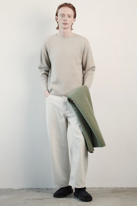 This image features the Axa Sweater, highlighted in a minimalistic style with a feather color. The sweater showcases an oversized fit with distinct drop shoulders and sculpted, rounded sleeves.