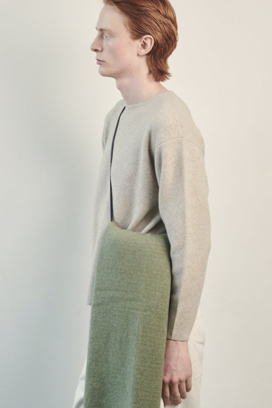 This image features the Axa Sweater, highlighted in a minimalistic style with a feather color. The sweater showcases an oversized fit with distinct drop shoulders and sculpted, rounded sleeves.