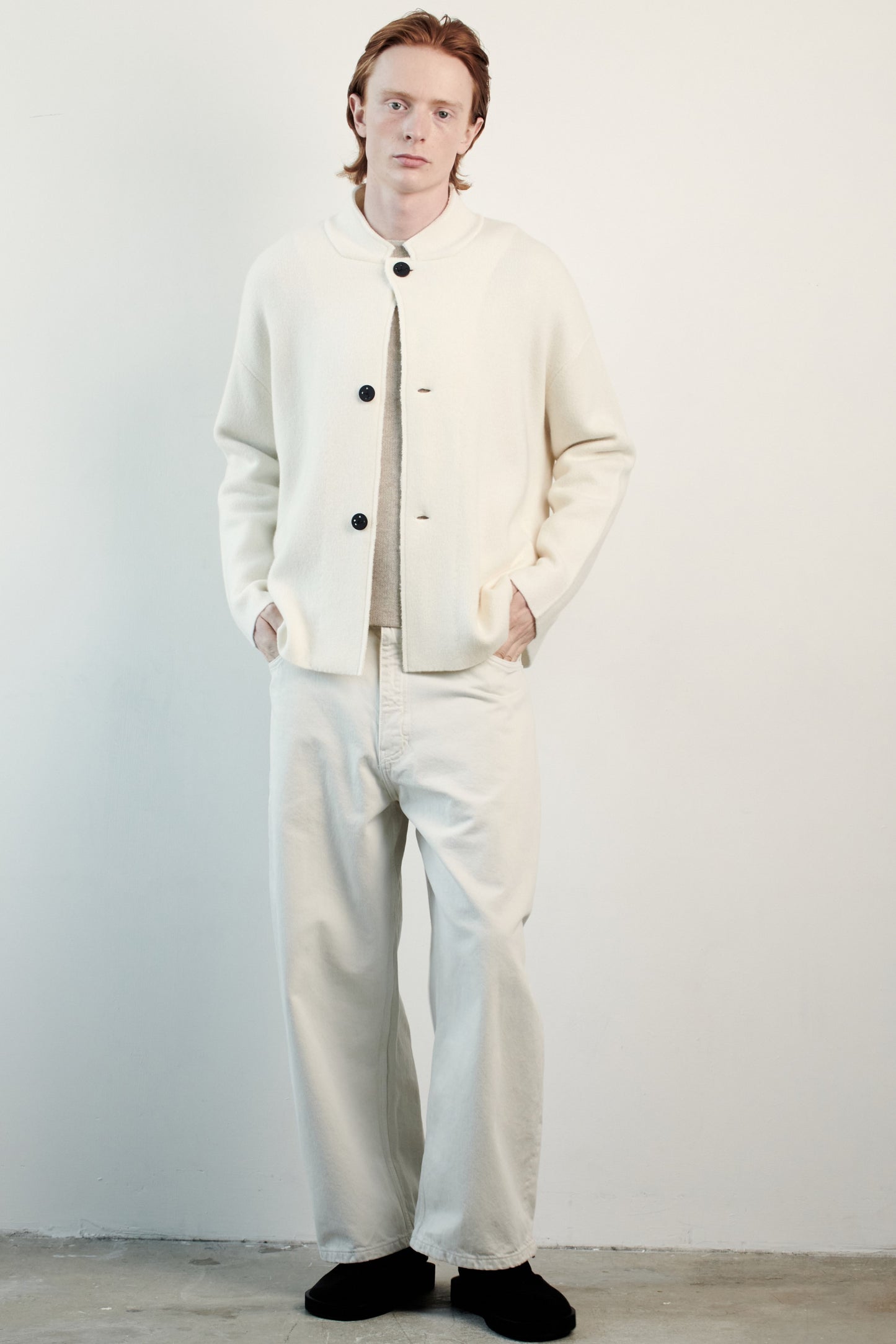 This image features a model wearing the Wind Jacket from Oyuna's core collection. The jacket is designed with a relaxed-fit and showcases a sophisticated look with its stand-up collar and welt pockets.