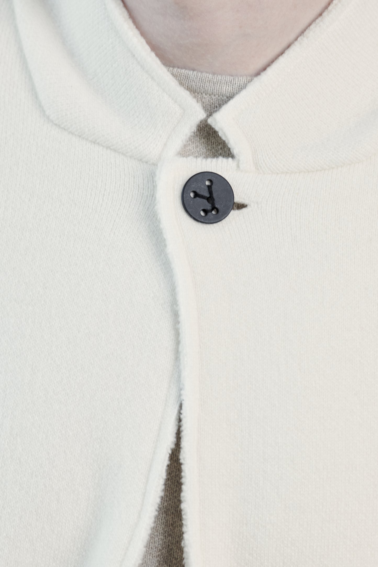 This image features a model wearing the Wind Jacket from Oyuna's core collection. The jacket is designed with a relaxed-fit and showcases a sophisticated look with its stand-up collar and welt pockets.