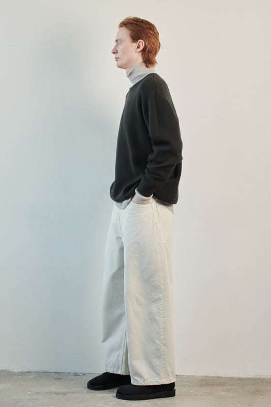 This image features the Axa Sweater, highlighted in a minimalistic style with a forest color. The sweater showcases an oversized fit with distinct drop shoulders and sculpted, rounded sleeves.