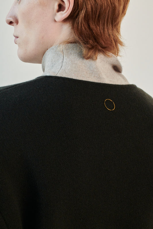 This image features the Axa Sweater, highlighted in a minimalistic style with a forest color. The sweater showcases an oversized fit with distinct drop shoulders and sculpted, rounded sleeves.