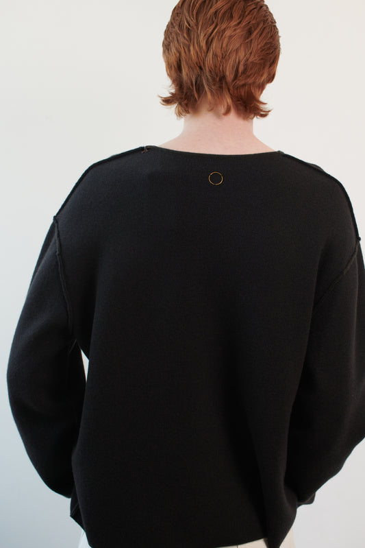 This image features the Axa Sweater, highlighted in a minimalistic style with a forest color. The sweater showcases an oversized fit with distinct drop shoulders and sculpted, rounded sleeves.