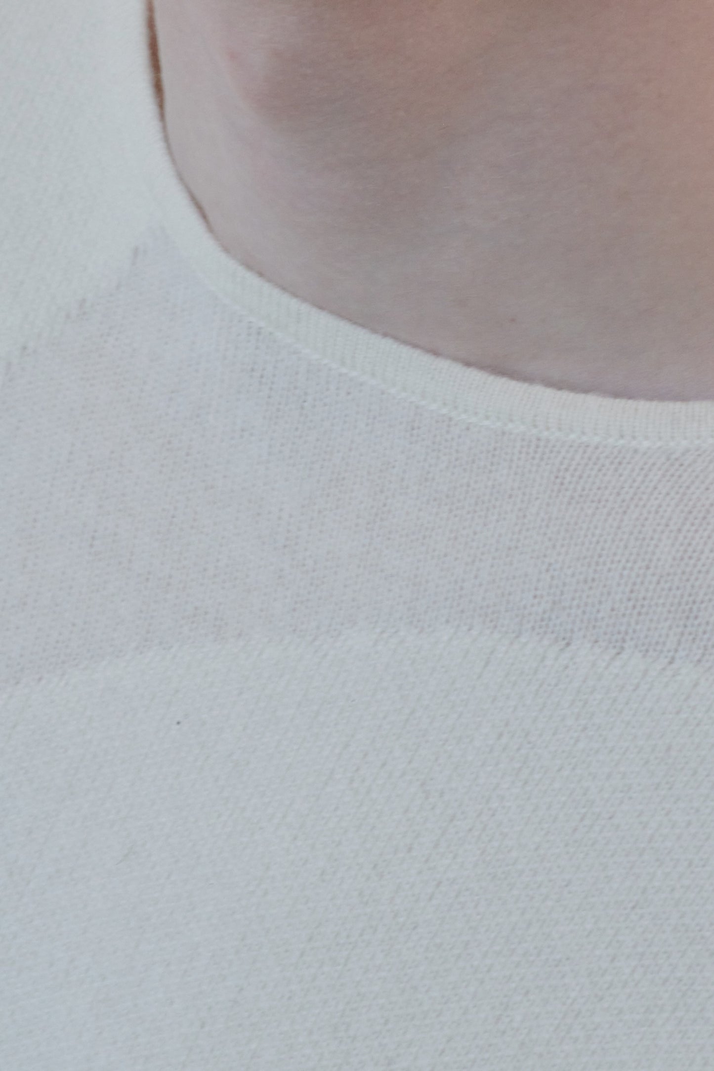 This image features the Arouc Sweater, a stylish and cozy garment that embodies a relaxed, everyday aesthetic. The sweater displays a boxy silhouette, crafted in a knitted jacquard print that forms an abstract, organic pattern in shades of ivory and feather.