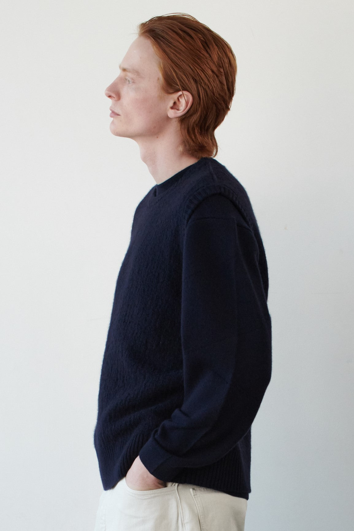This image features the Terra Top, a stylish knitted texture vest crafted from 100% cashmere, providing an unmatched softness and warmth. The model is seen wearing the vest showcasing the vest's sophisticated and subtle textured design.