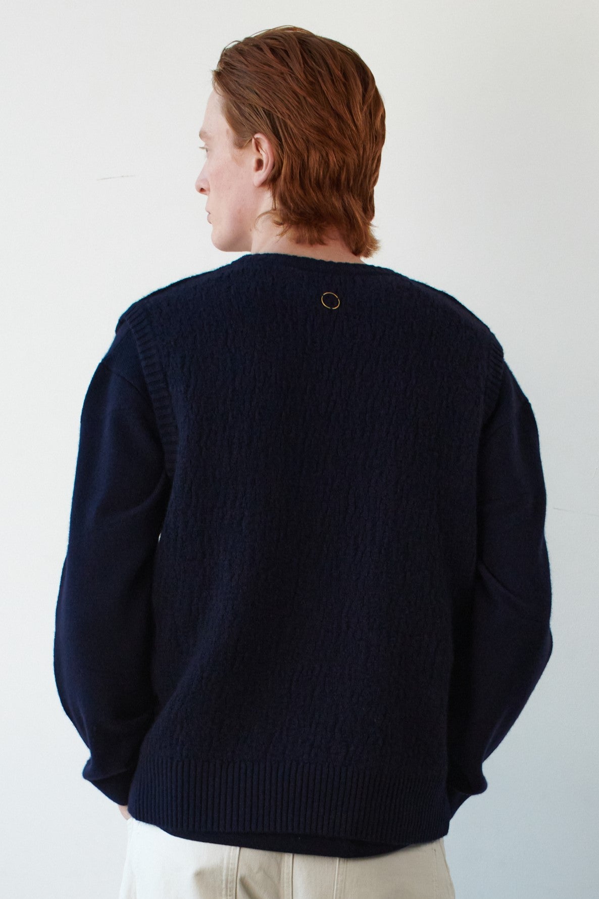 This image features the Terra Top, a stylish knitted texture vest crafted from 100% cashmere, providing an unmatched softness and warmth. The model is seen wearing the vest showcasing the vest's sophisticated and subtle textured design.