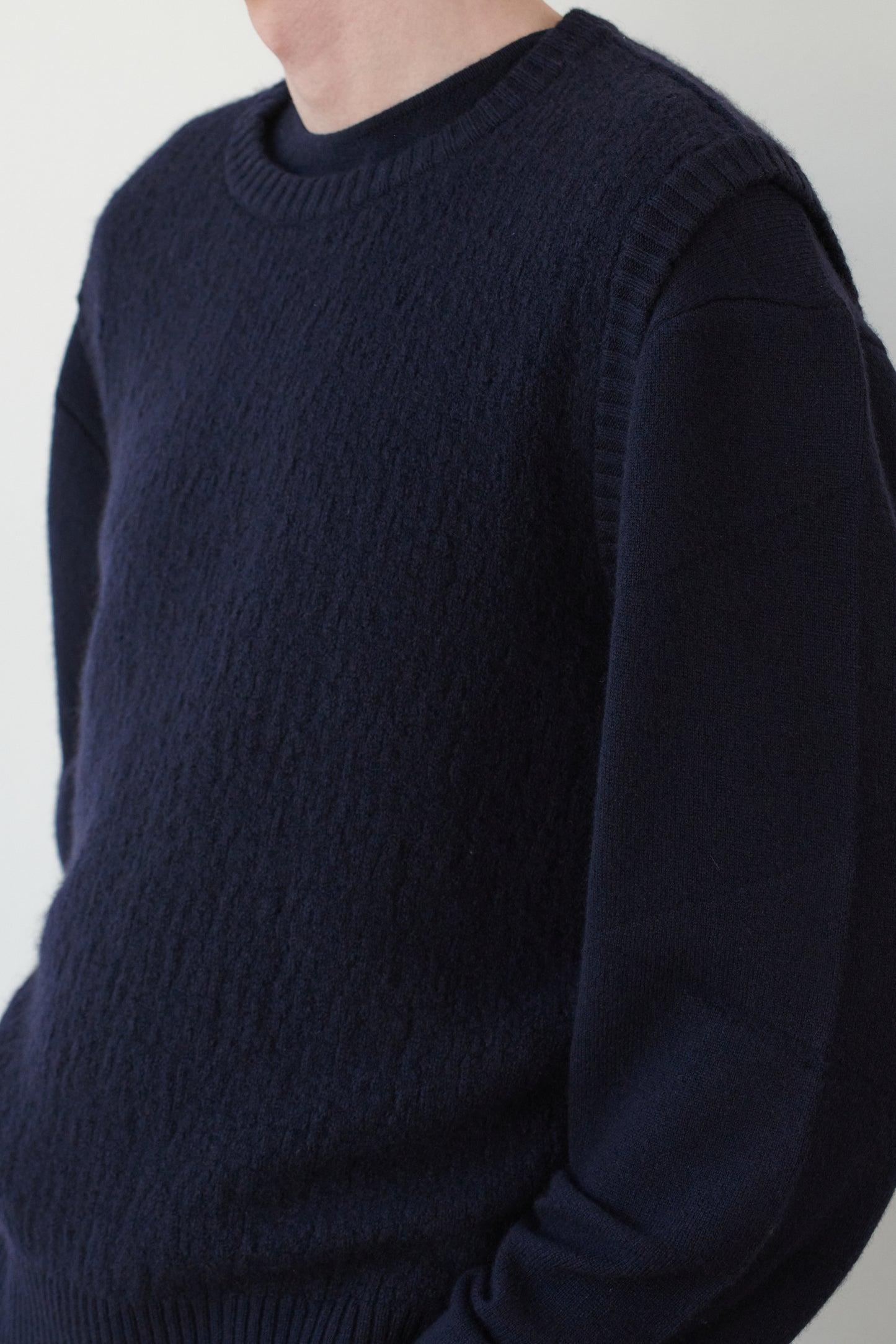 This image features the Terra Top, a stylish knitted texture vest crafted from 100% cashmere, providing an unmatched softness and warmth. The model is seen wearing the vest showcasing the vest's sophisticated and subtle textured design.