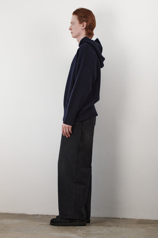 This image features a side view of the stylish and modern Seku Hoodie, presented in a quiet, modern ocean color. The model is seen wearing the hoodie, which drapes comfortably over the body, highlighting its soft and luxurious feel.