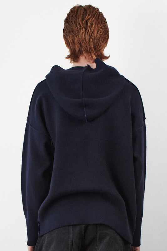 This back view image features a stylish and modern Seku Hoodie, presented in a quiet, modern ocean color. The model is seen wearing the hoodie, which drapes comfortably over the body, highlighting its soft and luxurious feel.