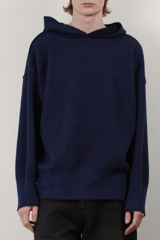 This image features a stylish and modern Seku Hoodie, presented in a quiet, modern ocean color. The model is seen wearing the hoodie, which drapes comfortably over the body, highlighting its soft and luxurious feel.