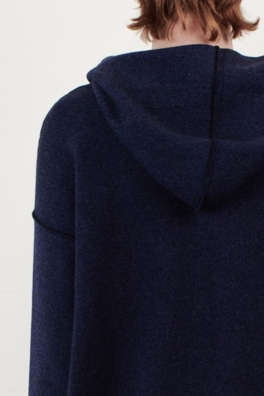 A close up back view of a person wearing the Seku hoodie in ocean, showing hem and stitch detail