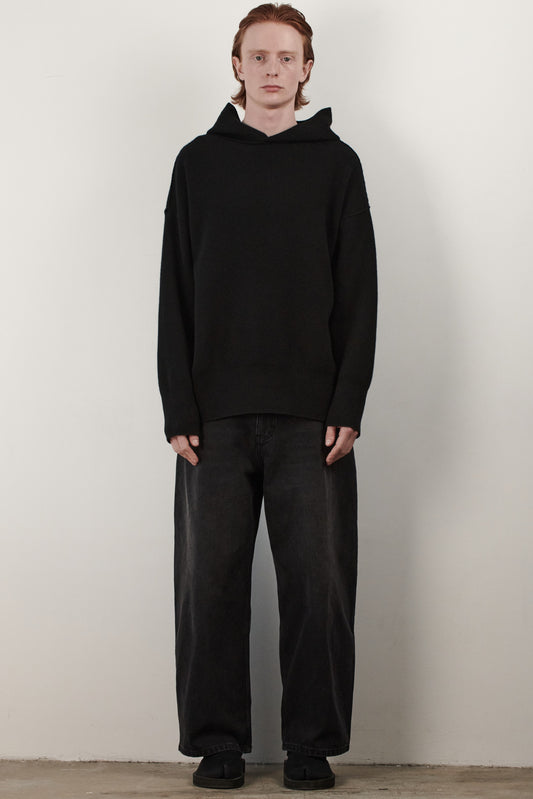 This image features a luxurious black cashmere hoodie, displayed against a neutral background to emphasize its design and color. The hoodie boasts a modern and minimalist look, with a soft and snug fit that promises comfort and style.