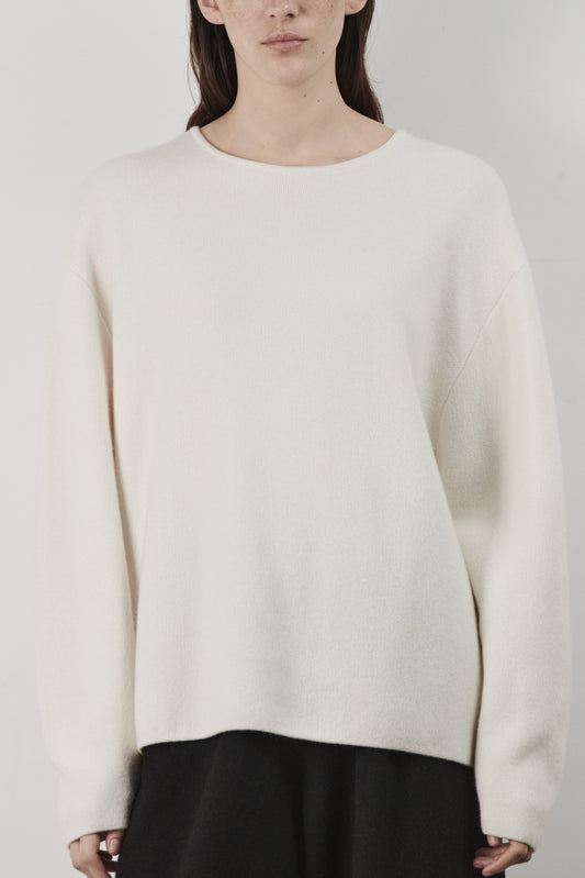 This image features the Axa Sweater, a stylish and comfortable piece that showcases an oversized fit with drop shoulders and sculpted, rounded sleeves. The sweater is knitted using a structured jacquard stitch, which adds texture and depth to its appearance.