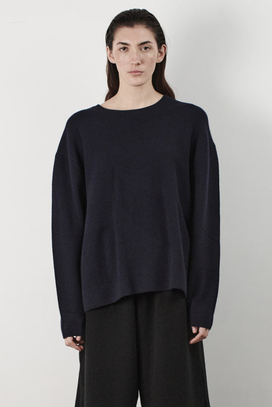 This image features the Arouc Sweater, a stylish and cozy garment ideal for everyday wear. The sweater displays a boxy silhouette and is crafted from a knitted jacquard fabric, presenting a subtle yet sophisticated pattern.