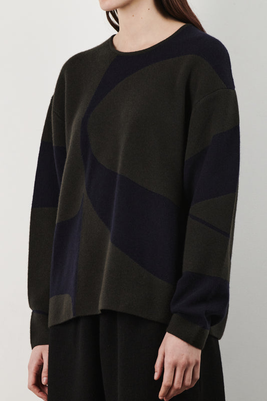 This image features the Arouc Sweater, a stylish and cozy garment ideal for everyday wear. The sweater displays a boxy silhouette and is crafted from a knitted jacquard fabric, presenting a subtle yet sophisticated pattern.
