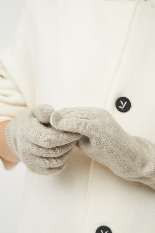 A person wearing feather knitted gloves.