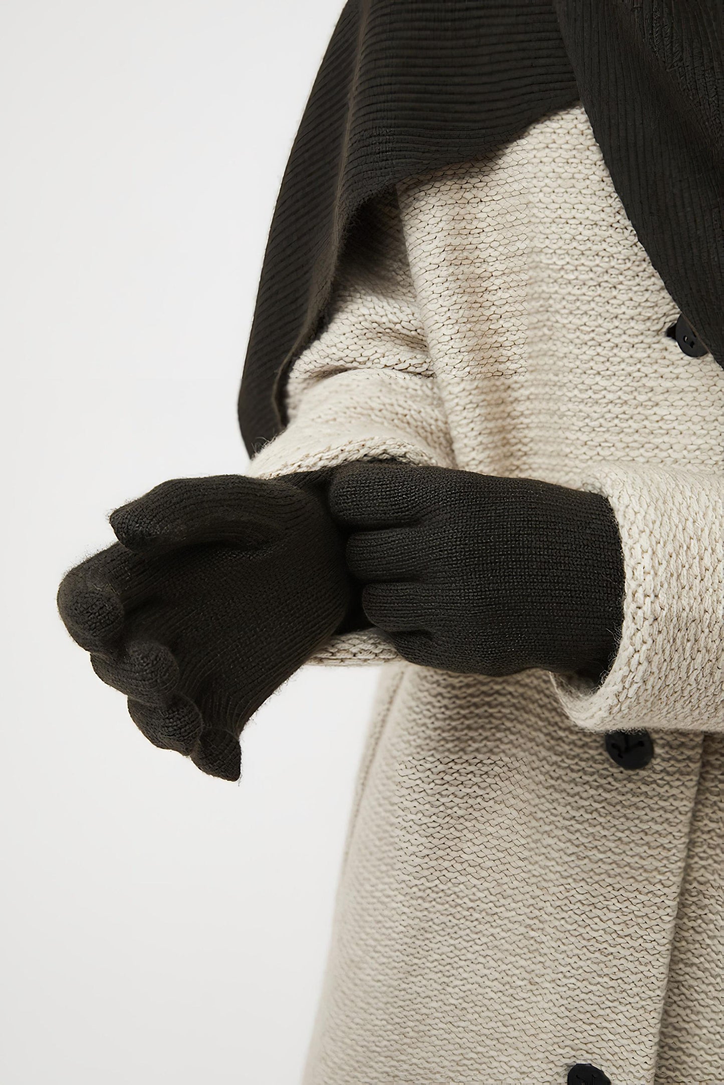 A person wearing forest knitted gloves.