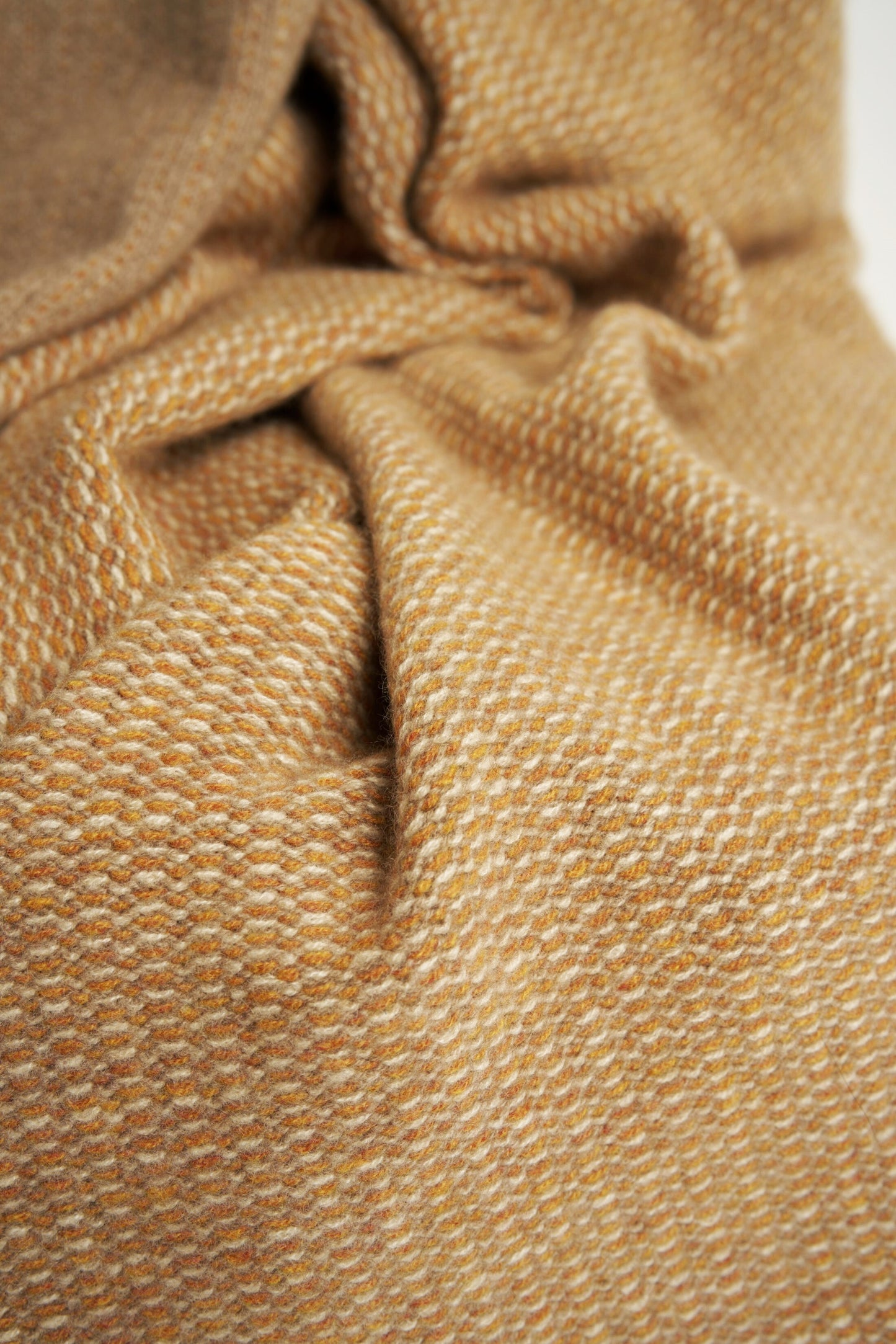 A close up of the Quadro throw in Honey & Taupe, showcasing the knit pattern