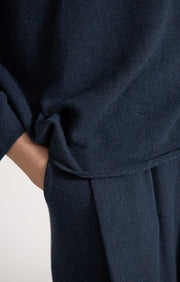 Woman wearing Sabi cotton sweater with dropped shoulders and cropped sleeves in colour Indigo. 