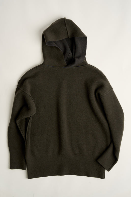 This image features a luxurious forest cashmere hoodie, modeled by a female. The hoodie boasts a modern and minimalist design, with a relaxed fit that enhances its appeal.