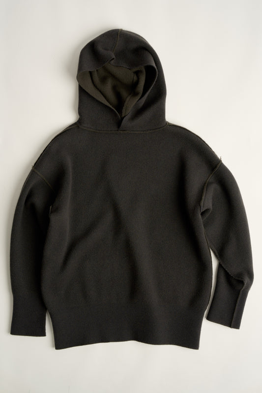 This image features a luxurious forest cashmere hoodie, modeled by a female. The hoodie boasts a modern and minimalist design, with a relaxed fit that enhances its appeal.