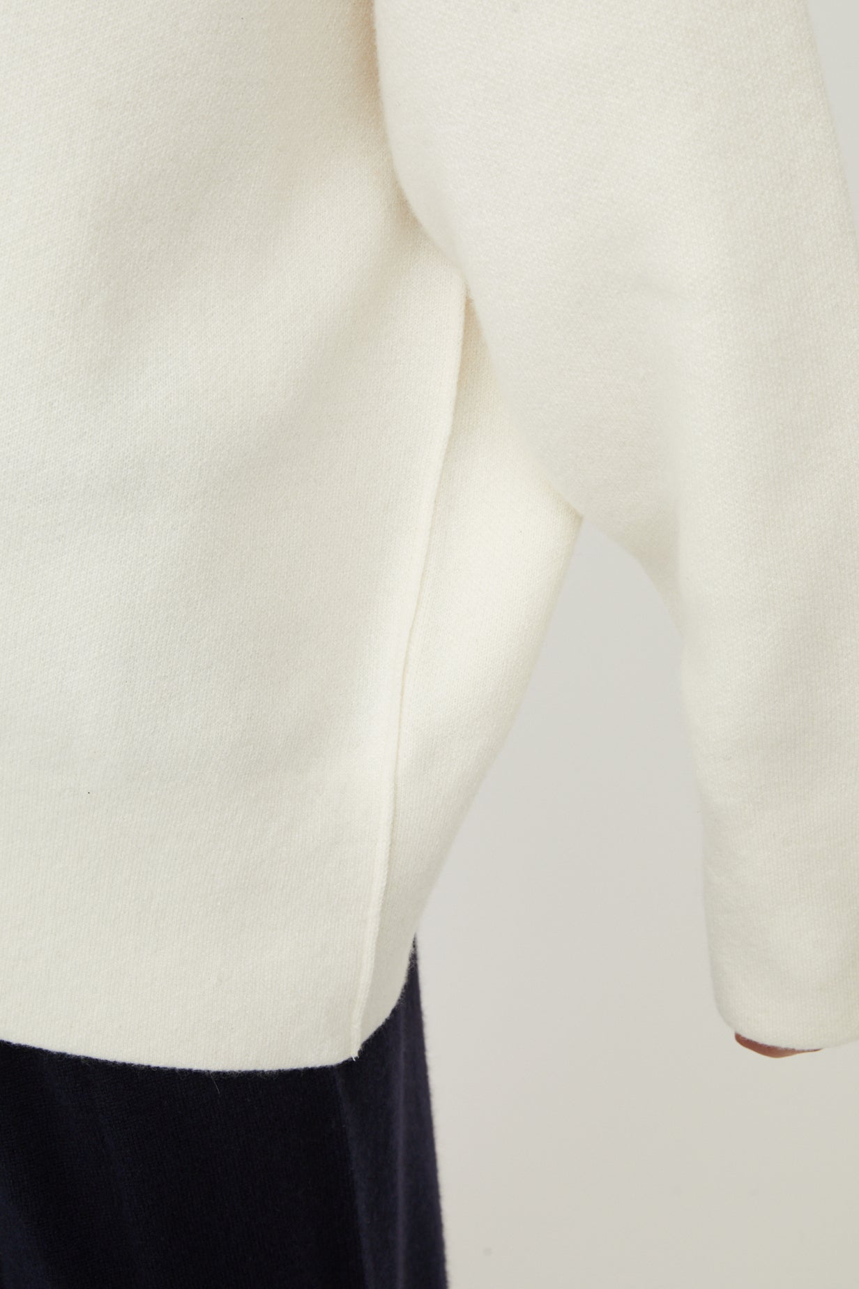 A close up of the Seku cashmere hoodie in ivory. Showing detail on the sleeve and hem