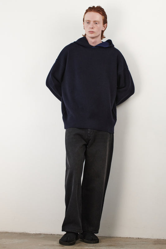 This image features a stylish and modern Seku Hoodie, presented in a quiet, modern ocean color. The model is seen wearing the hoodie, which drapes comfortably over the body, highlighting its soft and luxurious feel.