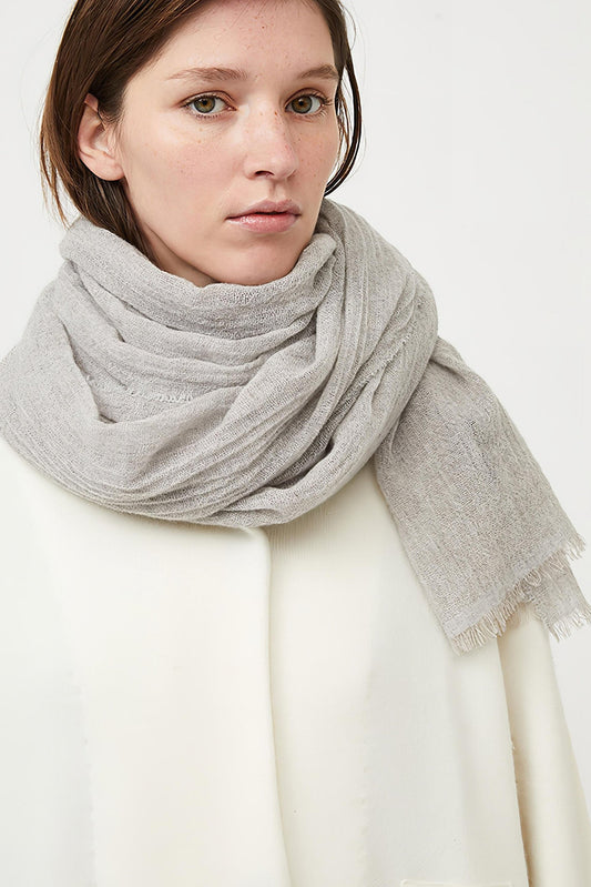 This image displays the Sera Shawl, a luxurious and elegant accessory crafted from the finest cashmere. The shawl features a subtle two-tone effect, achieved through a combination of different colors on the warp and weft, which enhances its sophisticated appeal.