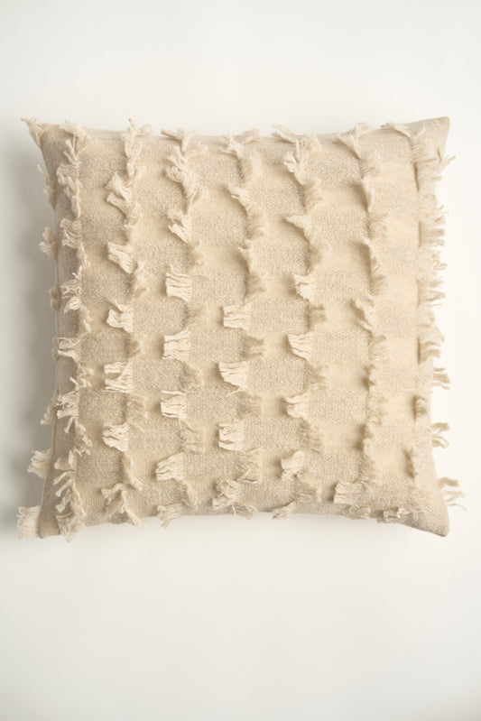 This image displays the Seren Cushion Cover, designed to bring a touch of serene elegance to any interior setting. The cushion cover features a distinct hand-cut fringe detail that adds a textured and dynamic touch.