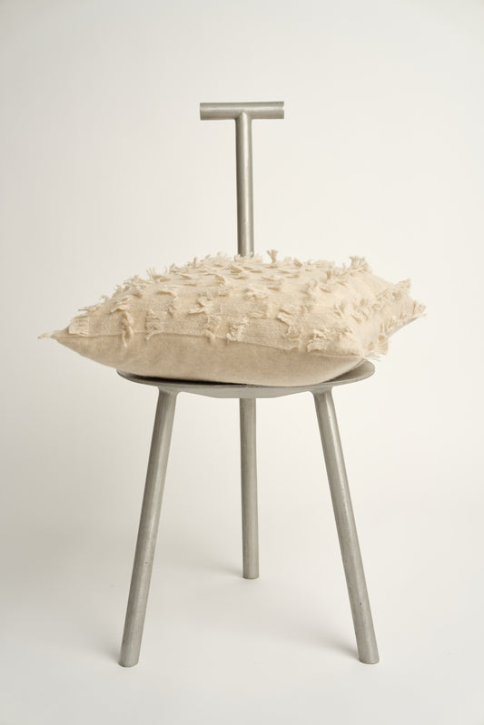 This image displays the Seren Cushion Cover, designed to bring a touch of serene elegance to any interior setting. The cushion cover features a distinct hand-cut fringe detail that adds a textured and dynamic touch.