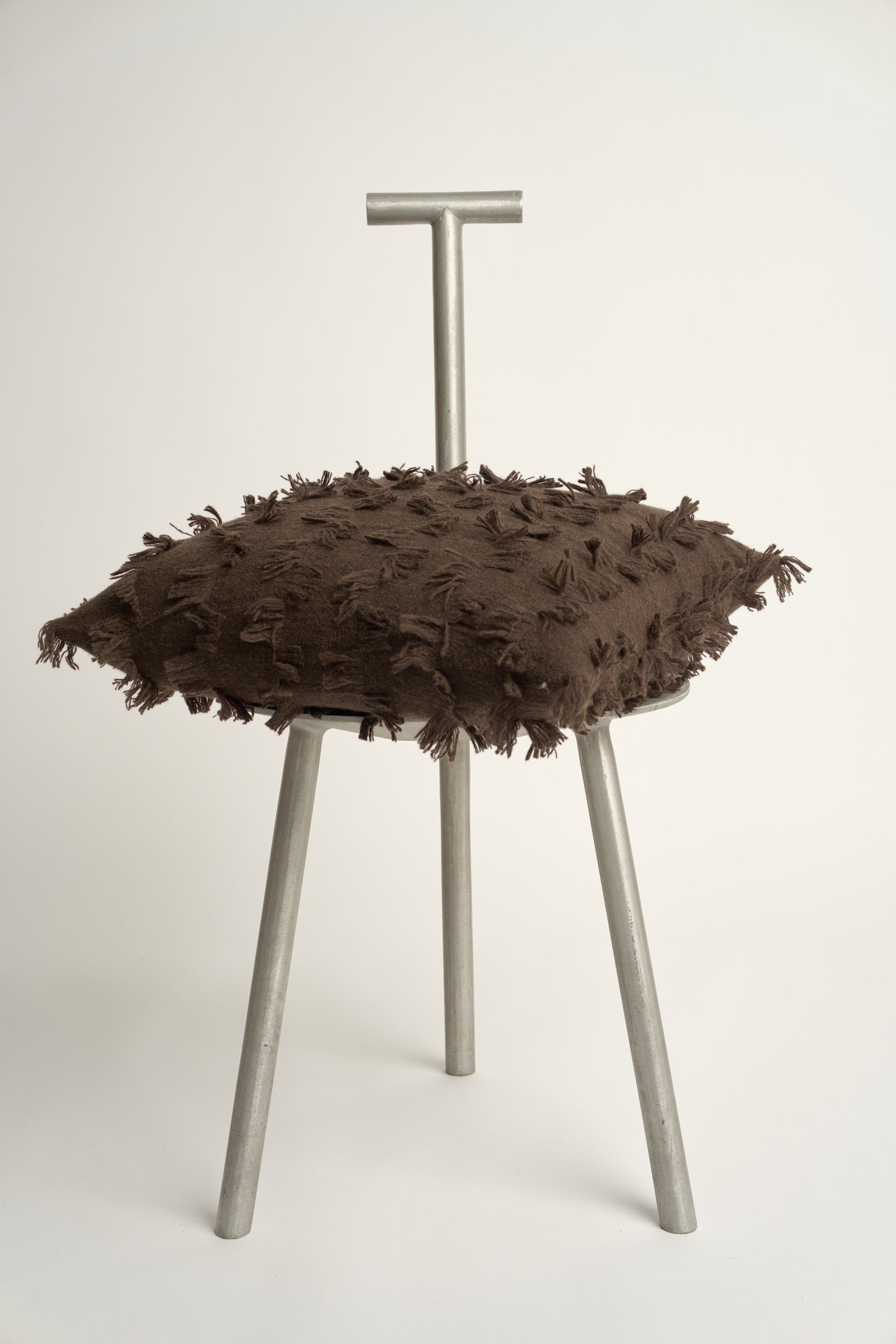 This image displays the Seren Cushion Cover, designed to bring a touch of serene elegance to any interior setting. The cushion cover features a distinct hand-cut fringe detail that adds a textured and dynamic touch.