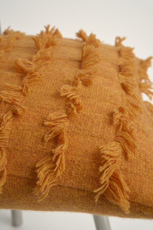 This image displays the Seren Cushion Cover, designed to bring a touch of serene elegance to any interior setting. The cushion cover features a distinct hand-cut fringe detail that adds a textured and dynamic touch.