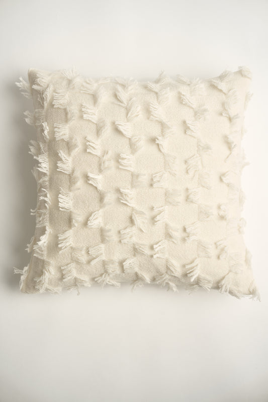 This image displays the Seren Cushion Cover, designed to bring a touch of serene elegance to any interior setting. The cushion cover features a distinct hand-cut fringe detail that adds a textured and dynamic touch.