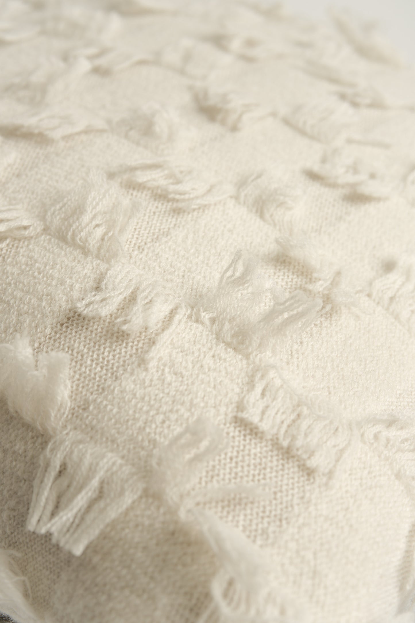 This image displays the Seren Cushion Cover, designed to bring a touch of serene elegance to any interior setting. The cushion cover features a distinct hand-cut fringe detail that adds a textured and dynamic touch.