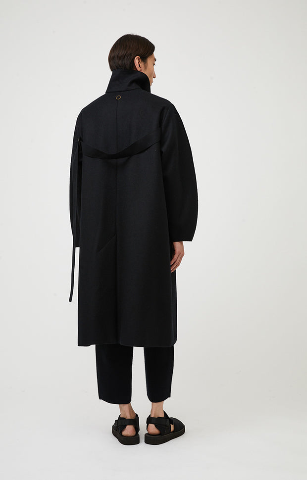 Person wearing Shield unisex woven cashmere collared coat in colour Black. 