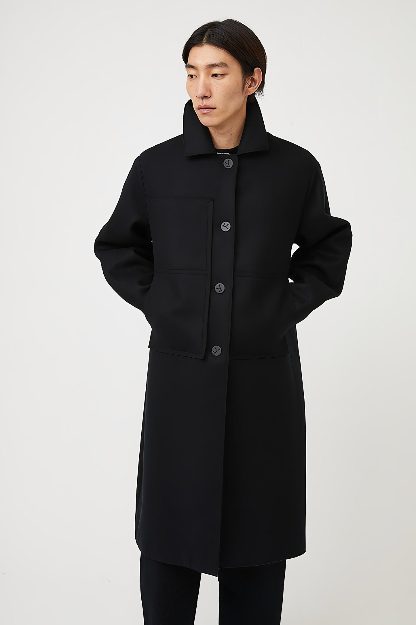 This image features a model wearing a sophisticated, heavyweight cashmere coat, which we refer to as the "Shield Coat". The coat is displayed in a deep, black color, enhancing its elegant and modern appeal.