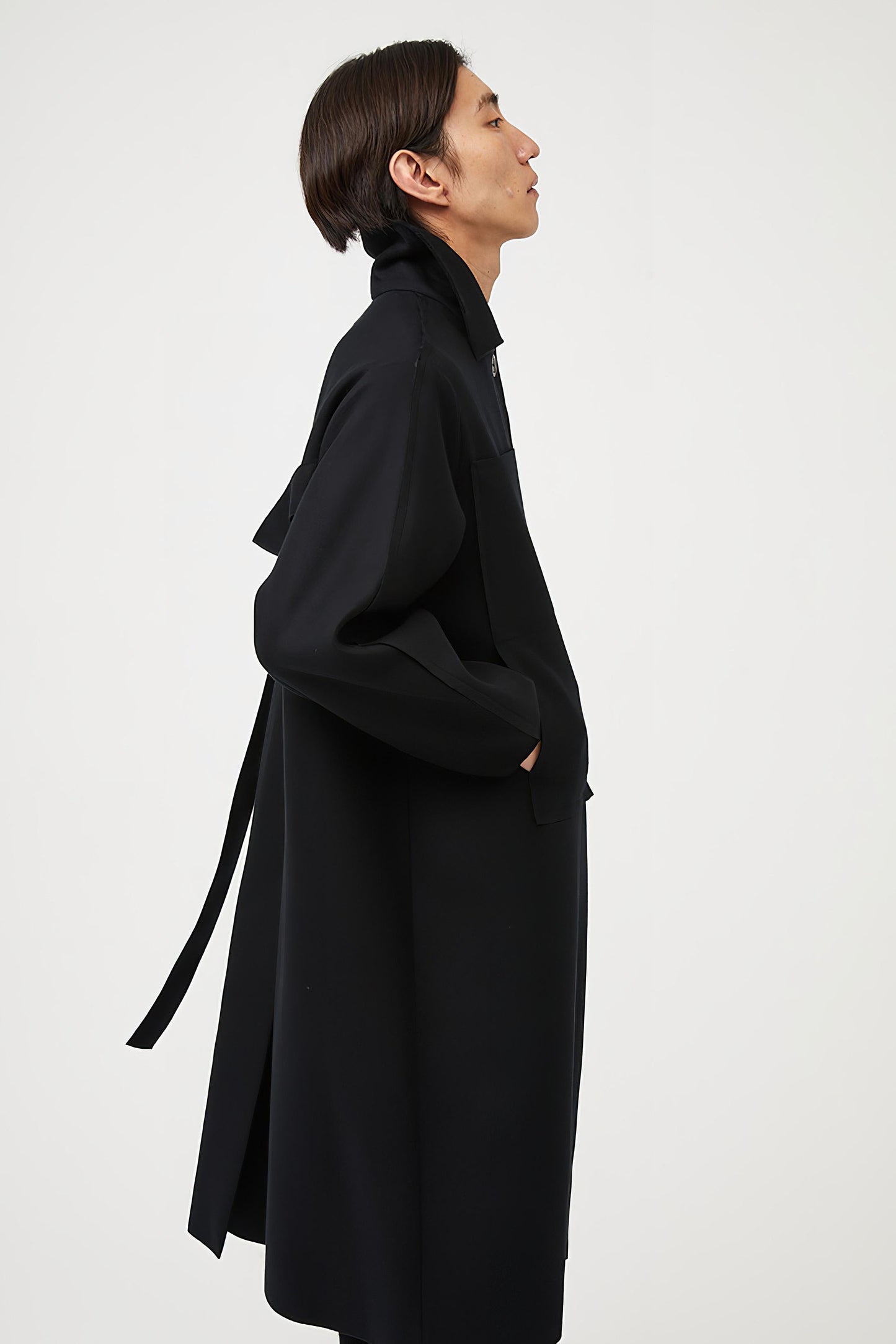This image features a model wearing a sophisticated, heavyweight cashmere coat, which we refer to as the "Shield Coat". The coat is displayed in a deep, black color, enhancing its elegant and modern appeal.