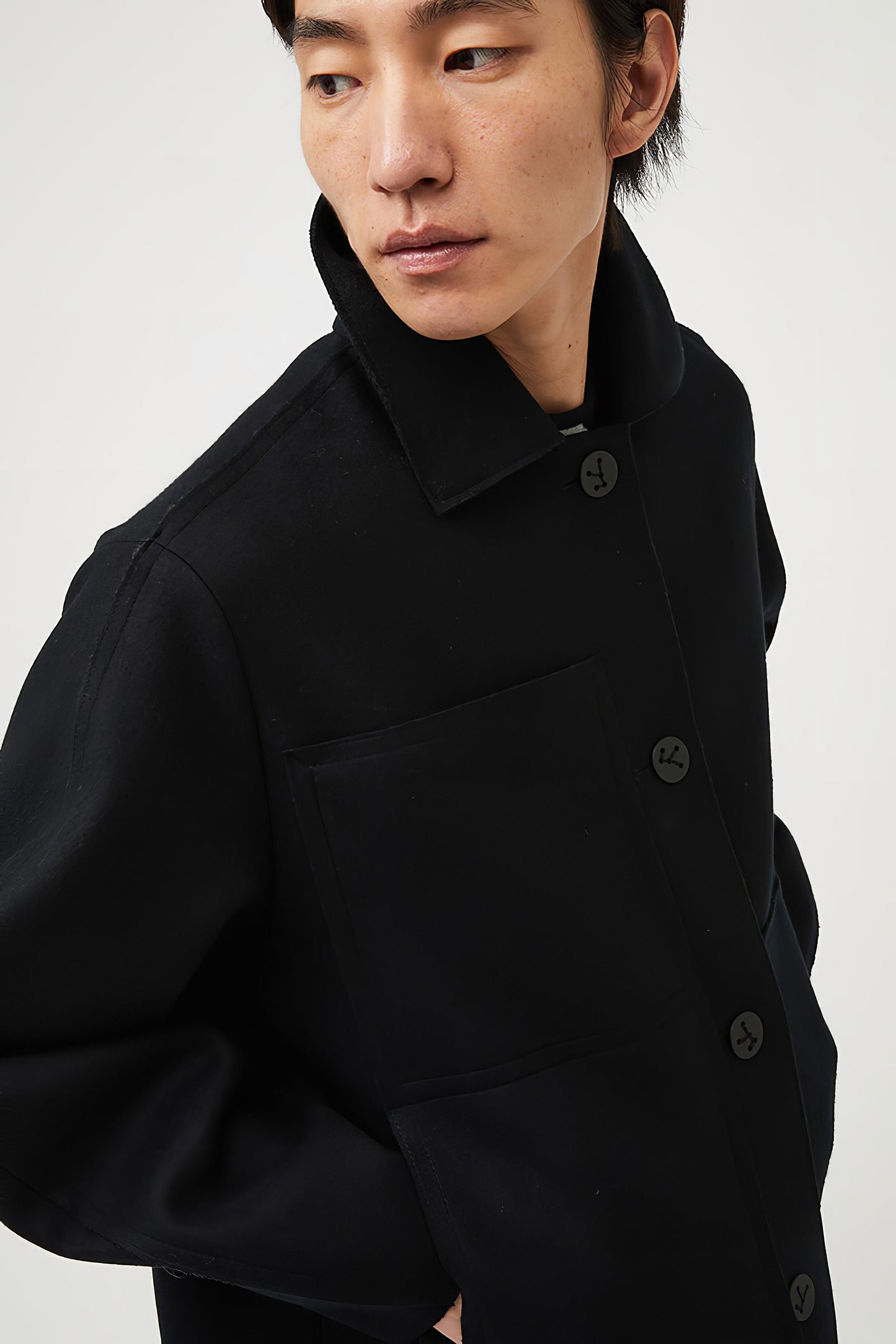 This image features a model wearing a sophisticated, heavyweight cashmere coat, which we refer to as the "Shield Coat". The coat is displayed in a deep, black color, enhancing its elegant and modern appeal.