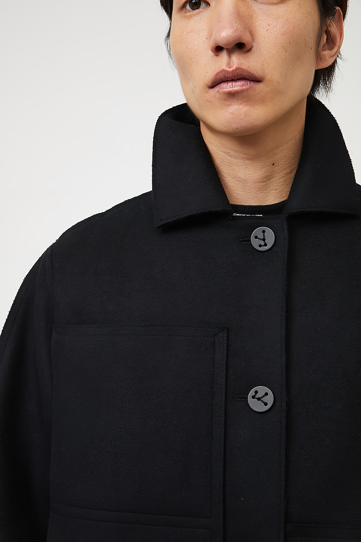 This image features a model wearing a sophisticated, heavyweight cashmere coat, which we refer to as the "Shield Coat". The coat is displayed in a deep, black color, enhancing its elegant and modern appeal.