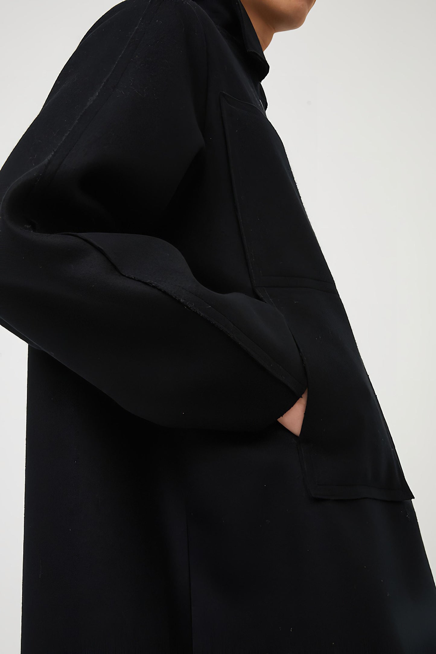 This image features a model wearing a sophisticated, heavyweight cashmere coat, which we refer to as the "Shield Coat". The coat is displayed in a deep, black color, enhancing its elegant and modern appeal.