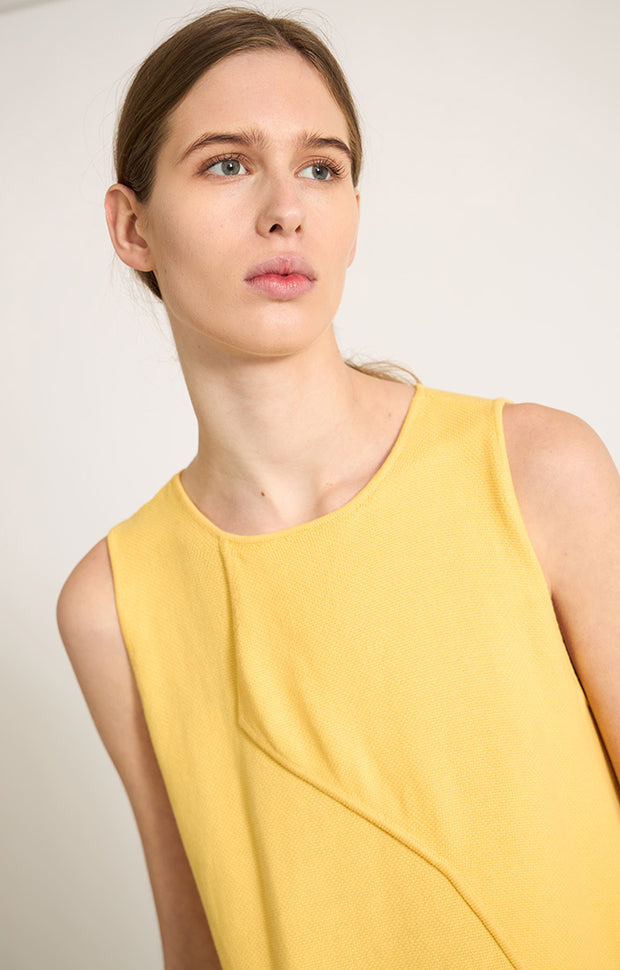 Woman wearing Sinca sleeveless cotton top in colour Lemon. 