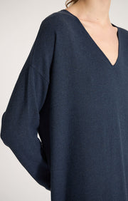 Woman wearing Sylva linear relaxed fit cotton dress with v shaped neckline in colour Indigo. 